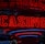 Neon lights display the word 'CASINO' in bright red, standing out against a dark background. The vibrant glow reflects a lively and bustling atmosphere.